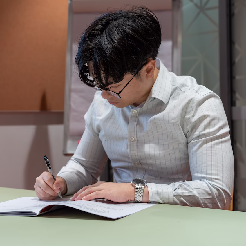 Our founder Vincent Tran writing on a Zeta Education theory booklet.